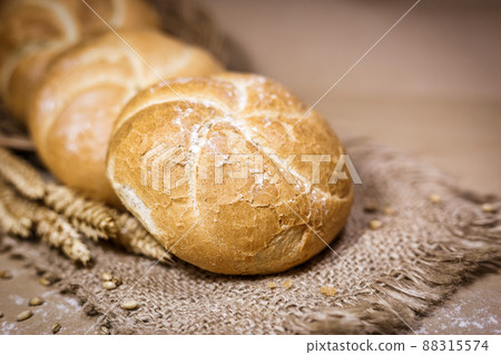 Fresh bread and wheat on a rustic background Fresh bread and wheat on a rustic background 88315574