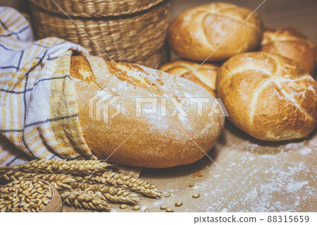 Fresh bread and wheat on a rustic background 88315659