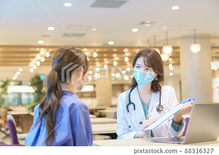 Young woman receiving medical treatment from an industrial physician 88316327