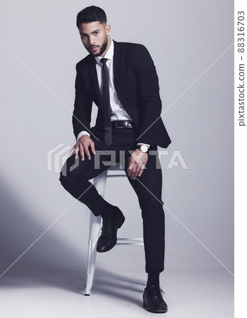 Wearing my best suit. Studio shot of a young man posing against a grey background. Wearing my best suit. Studio shot of a young man posing against a grey background. 88316703