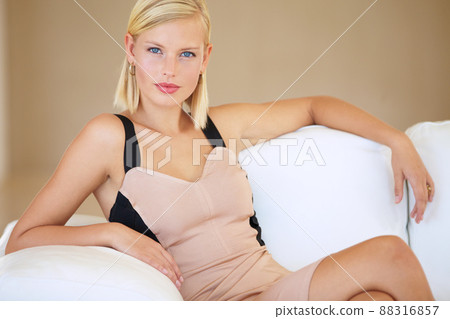 Living the high life. Beautiful young blonde woman sitting on a white couch. 88316857