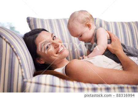 Hes my pride and joy. Portrait of an attractive young woman and her baby girl lying on the sofa. 88316994