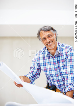 Happy engineer smiling. Portrait of handsome mature architect smiling with blueprint in hand. Happy engineer smiling. Portrait of handsome mature architect smiling with blueprint in hand. 88317081