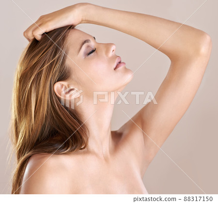 Breathtaking beauty. Portrait of a sexy bare-shouldered model posing with her hand in her hair and her eyes closed. 88317150