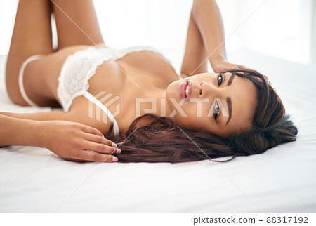 She feels confident in her body. Portrait of a gorgeous young woman posing seductively on her bed. 88317192