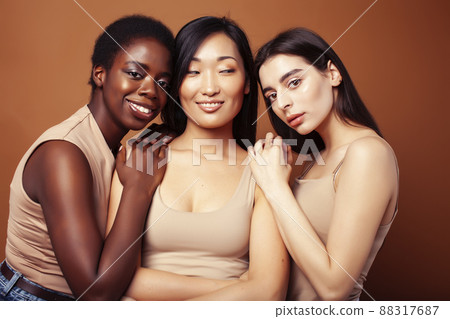 young pretty asian, caucasian, african woman posing cheerful together on brown background, lifestyle diverse nationality people concept 88317687