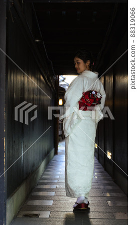 A Japanese woman wearing a kimono and looking back on a path in Gion, Kyoto A Japanese woman wearing a kimono and looking back on a path in Gion, Kyoto 88319066