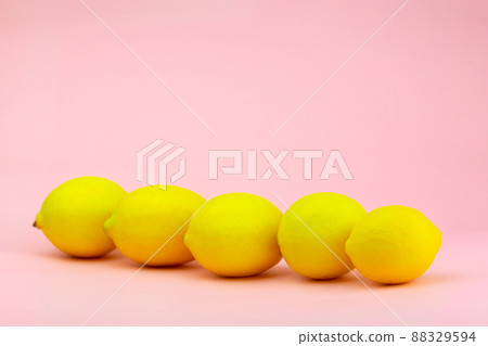 Lemons laid diagonally on a pink background Lemons laid diagonally on a pink background 88329594