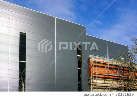 the facade of an old brick house is integrated into a new modern building the facade of an old brick house is integrated into a new modern building 88331629