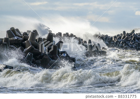 coastal storm in the baltic sea, big waves crash against the harbor breakwater 88331775