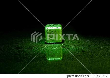 Green stainless steel cubes simulating ice for cooling drinks on a black surface with a reflection. Green stainless steel cubes simulating ice for cooling drinks on a black surface with a reflection. 88331957