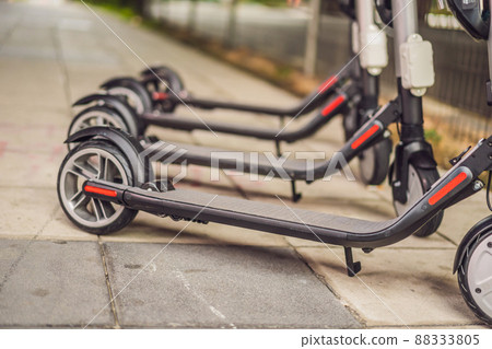 Electric scooters for rent. urban transport. Electric Ride Sharing Scooters Lined Up and Ready to Rent Electric scooters for rent. urban transport. Electric Ride Sharing Scooters Lined Up and Ready to Rent 88333805