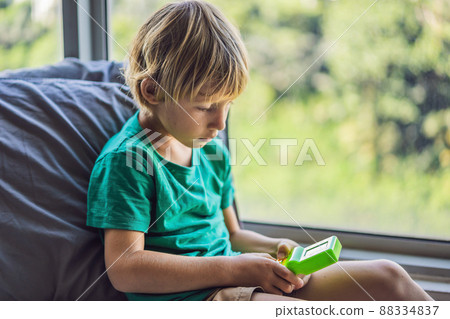 Young boy playing old school portable game console, electronic retro pocket toy with monochrome display Young boy playing old school portable game console, electronic retro pocket toy with monochrome display 88334837