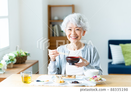 Senior woman eating breakfast Senior woman eating breakfast 88335198