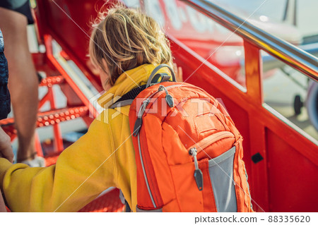 Little boy traveler boarding on the plane Little boy traveler boarding on the plane 88335620