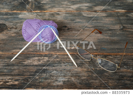 Yarn balls, knitting needles and glasses Yarn balls, knitting needles and glasses 88335973