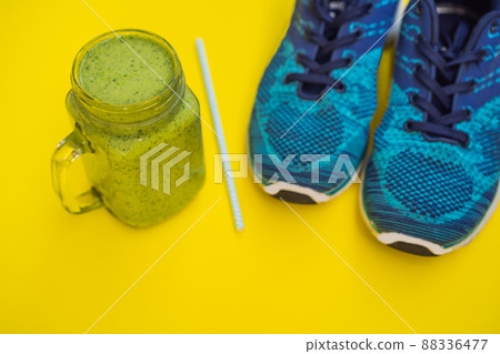 Everything for sports turquoise, blue shades on a yellow background and spinach smoothies. Yoga mat, sport shoes sportswear and bottle of water. Concept healthy lifestyle, sport and diet. Sport 88336477