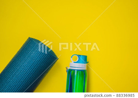 Everything for sports turquoise, blue shades on a yellow background. Yoga mat, sport shoes sportswear and bottle of water. Concept healthy lifestyle, sport and diet. Sport equipment. Copy space Everything for sports turquoise, blue shades on a yellow background. Yoga mat, sport shoes sportswear and bottle of water. Concept healthy lifestyle, sport and diet. Sport equipment. Copy space 88336985