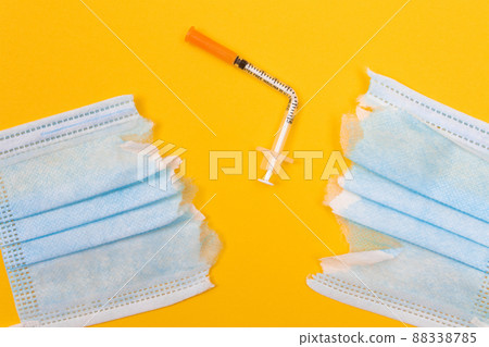 Broken Medical Syringe and Torn Medical Face Mask 88338785