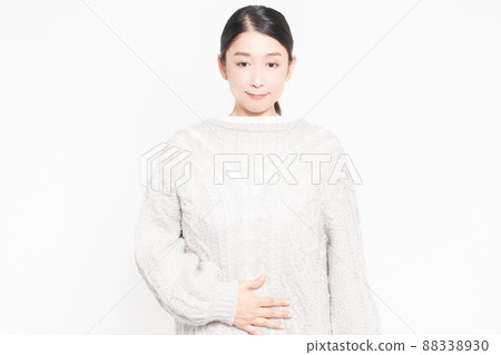 一個女人站在白色背景前，雙手放在肚子上 88338930