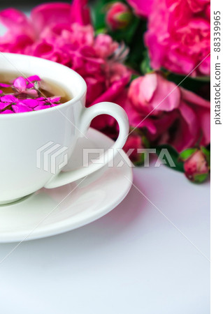 Creative layout with pink peonies flowers and cup of tea on bright table. Spring Seasonal valentine, woman, mother, 8 march holiday, romance breakfast. Stylish blogger. Greeting card Creative layout with pink peonies flowers and cup of tea on bright table. Spring Seasonal valentine, woman, mother, 8 march holiday, romance breakfast. Stylish blogger. Greeting card 88339965