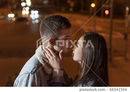 Couple of students intend to kiss against evening city backdrop. Date. Romance. 88341504