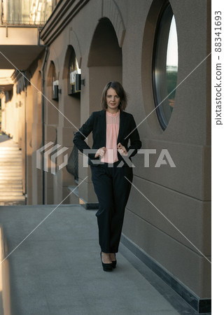 Successful director wearing black suit and heels. Business woman in formal business clothing. Street portrait Successful director wearing black suit and heels. Business woman in formal business clothing. Street portrait 88341693