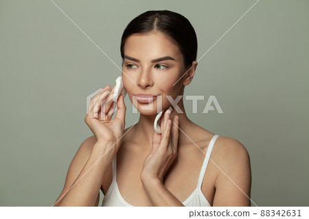 Portrait of cute young woman with white cotton pads, female routine Portrait of cute young woman with white cotton pads, female routine 88342631