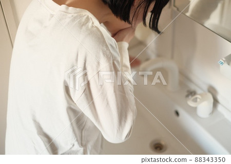 Pregnant woman suffering from morning sickness in the washbasin 88343350