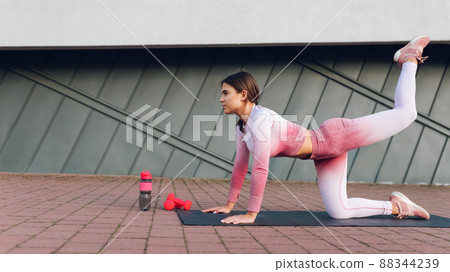 Fitness girl doing buttocks exercises on the mat.  88344239