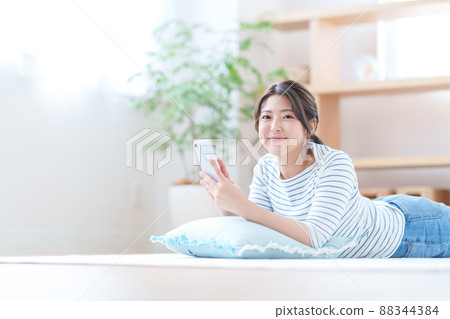 做智能手機的少婦在客廳 88344384