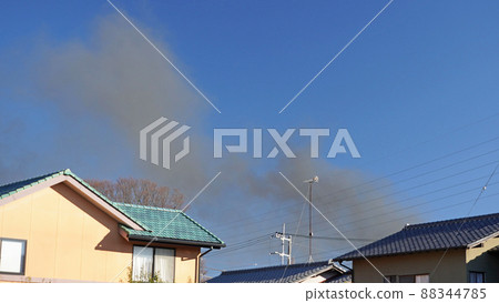 Black smoke from a fire in a residential area 88344785