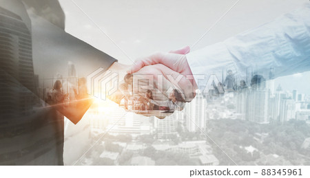 Business partner shaking hands in city with double exposure of interface data. Teamwork concept. Business partner shaking hands in city with double exposure of interface data. Teamwork concept. 88345961