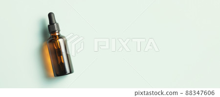 Amber glass dropper bottle with black lid on green background. Skincare products , natural cosmetic. Beauty concept for face and body care. Banner 88347606