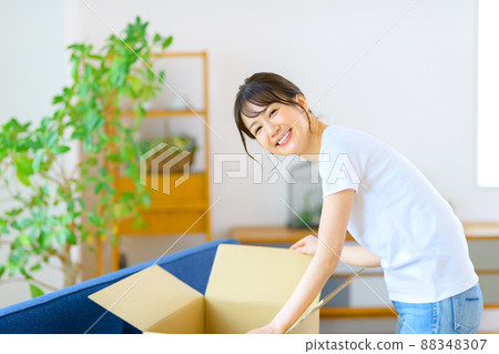 A woman checking mail order luggage at home Stock Photo 88348307 PIXTA
