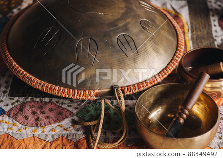 Tongue drum and Tibetan bowls lying on the carpet 88349492