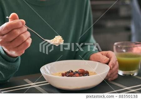 Senior woman eating oatmeal 88350138