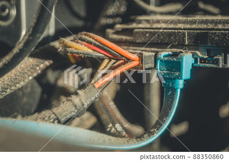 Dusty hard drive connection wires on your desktop computer. A layer of dust and dirt on the insulation of the power cables. Selective focus Dusty hard drive connection wires on your desktop computer. A layer of dust and dirt on the insulation of the power cables. Selective focus 88350860