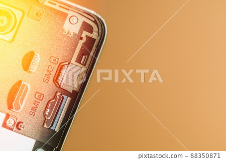Smartphone with open back cover and solar illumination. Slots for SIM cards. Selective focus, blur, copy space 88350871