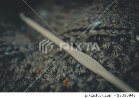 Knitting hook 300mm. Natural yarn made of wool. His hobby is hand knitting. Selective focus, black background 88350942
