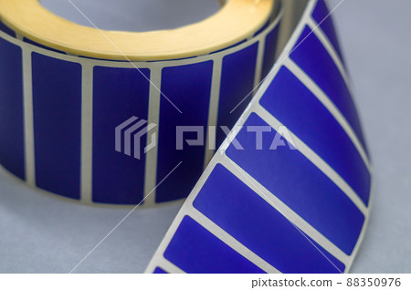Blurred roller tape blue self-adhesive label. Material for printing and marking products. Thermal label. Selective focus, copy space Blurred roller tape blue self-adhesive label. Material for printing and marking products. Thermal label. Selective focus, copy space 88350976