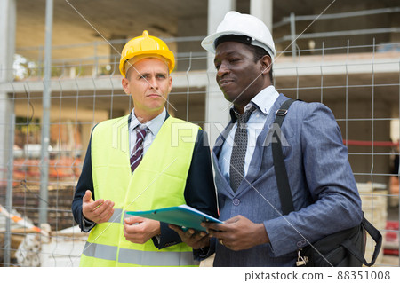 African-american architect discusses a construction plan with an engineer African-american architect discusses a construction plan with an engineer 88351008