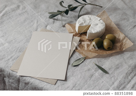 Tasty breakfast, snack still life. Blank greeting card, restaurant menu mockup. Fresh creamy camembert cheese with olive tree fruit, leaves. Grey linen table cloth background. Mediterranean food. Tasty breakfast, snack still life. Blank greeting card, restaurant menu mockup. Fresh creamy camembert cheese with olive tree fruit, leaves. Grey linen table cloth background. Mediterranean food. 88351898