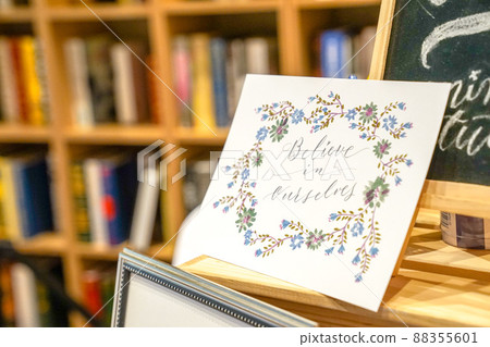 caligraphic card stand on wood table and front of backboard and library. 88355601