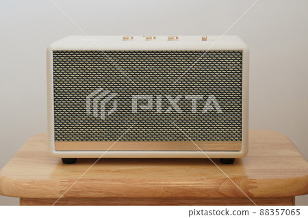 front view white and gold loudspeaker on wooden chair, white wall background, technology, object, fashion, decor, copy space 88357065