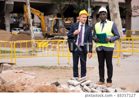 Architect tells engineer where to dig a trench to lay pipe Architect tells engineer where to dig a trench to lay pipe 88357127