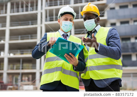 Engineers in masks standing on construction site 88357172