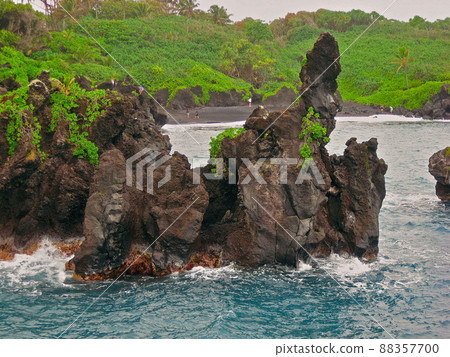 Visitors Explore the Lava Cliffs at Waianapanapa State Park in Hana, Hawaii on the island of Maui Visitors Explore the Lava Cliffs at Waianapanapa State Park in Hana, Hawaii on the island of Maui 88357700