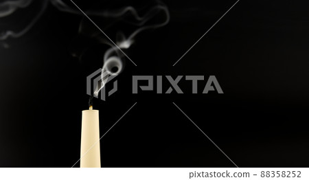 Blown out candle over a black background Blown out candle over a black background 88358252