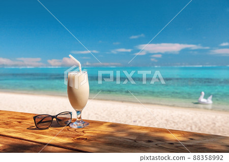Coconut shake pina colada drink cocktail milkshake at beach bar in Bora Bora island, Tahiti, French Polynesia. Ocean view with tall milk drinking glass on table 88358992
